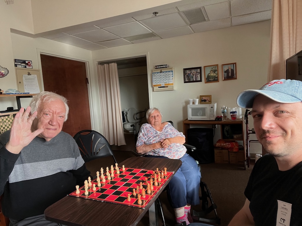 me and my grandpa playing chess with my grandmother in the background